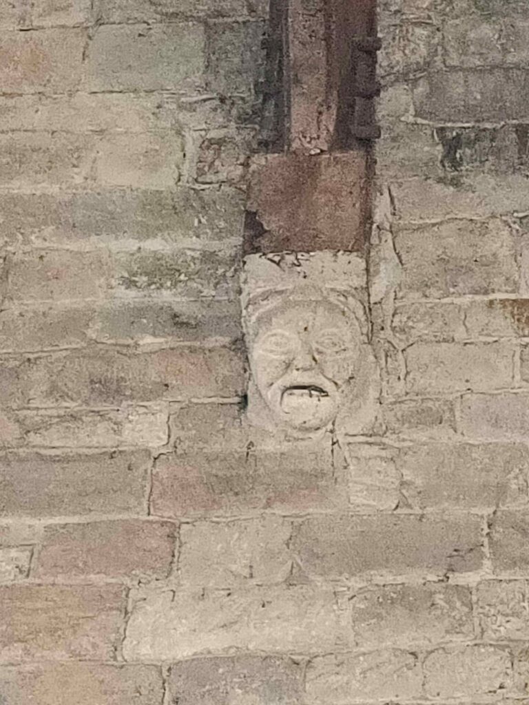 a roof corbel, carved into a grotesque