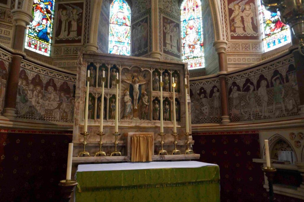 The High Altar with an Albury, and very tall candles, crucifixion scene in the centre