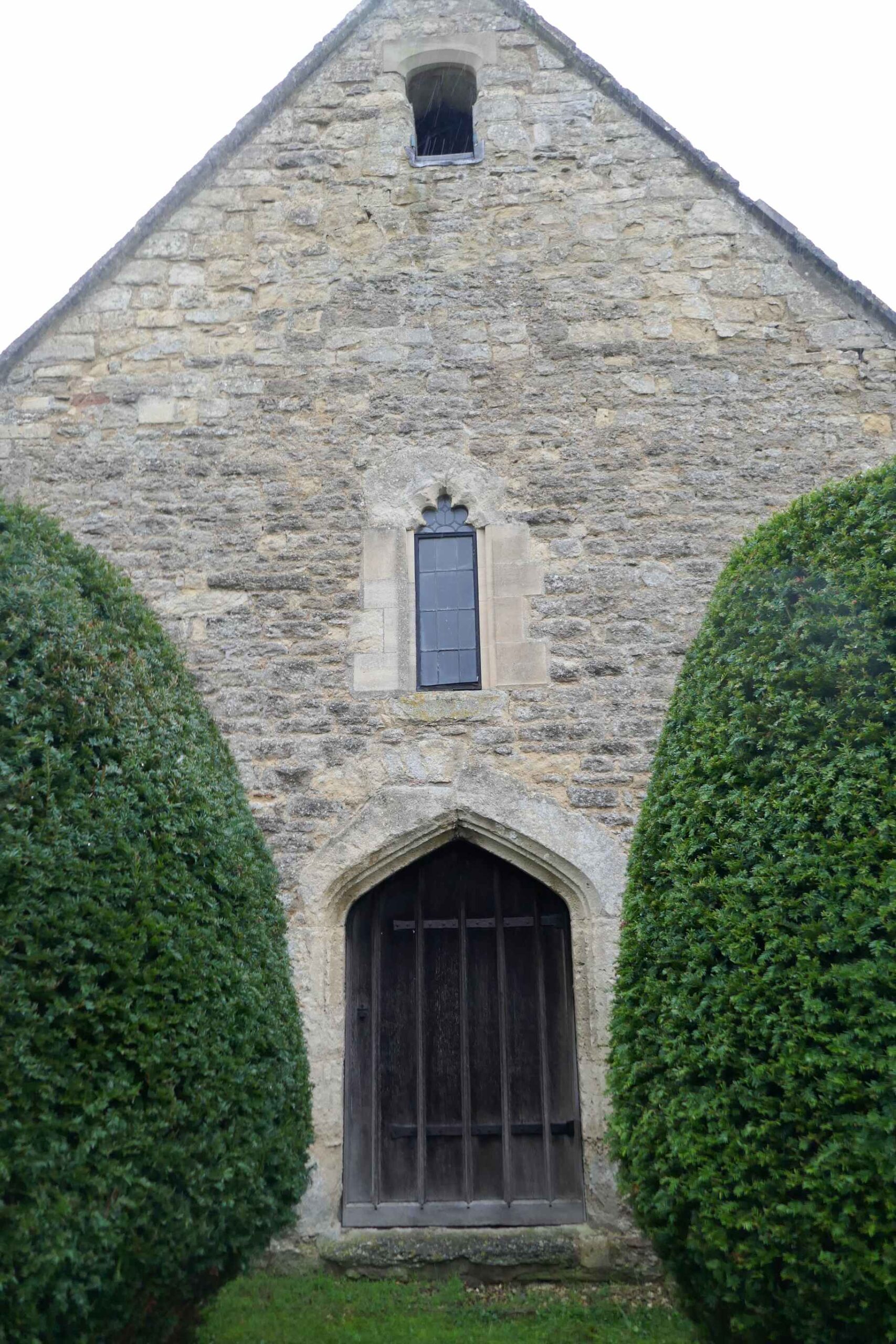 The west door and window, surrounded by well trimmed trees